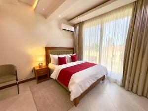 a bedroom with a bed and a large window at Comfort Retreat 2 in Dar es Salaam