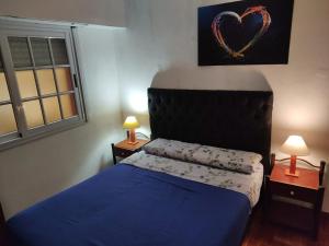 a bedroom with a blue bed and two tables with lamps at Hostelmo Hotel in Buenos Aires +67 photos