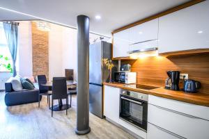 a kitchen with a table and a dining room at The Comfortable Loft in Ljubljana