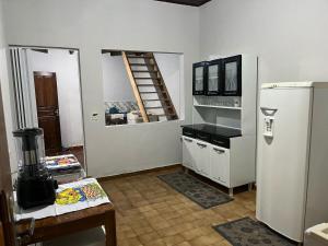 a kitchen with a refrigerator and a ladder on the wall at Casa da Vila 3 in Cáceres +9 photos