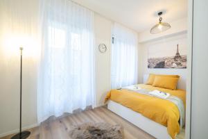 巴塞尔Studio Apartment - Central - Kitchen - self check in的一间卧室设有黄色的床和窗户。