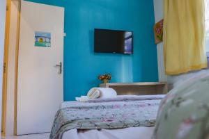 a bedroom with a bed with a blue wall at A Casa Morro do Moreno in Vila Velha