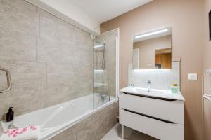 GuermantesAkropolis by Kleidos - Disney 15 mn - Beau duplex familiale pour 6 - 2 chambres- Parking Gratuit的浴室设有白色浴缸、水槽和浴缸。