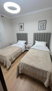 a bedroom with two beds and a large ceiling at Magnolia's Apartment in Yzberishti