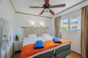 Un dormitorio con una cama con dos toallas azules encima. en Sunsuites Collection - Las Flores, en San Bartolomé 25 fotos más