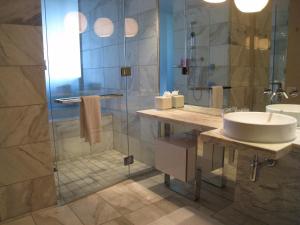 a bathroom with a sink and a glass shower at Palms Place- Strip View- High floor- Free parking in Las Vegas +9 photos