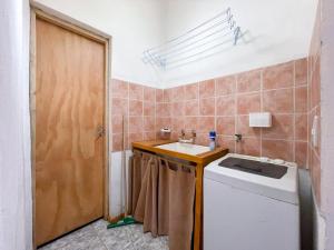 Un baño con lavabo y lavadora. en Alojamiento Las Retamas, en El Bolsón