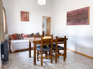 Un comedor con una mesa y sillas y un sofá. en Alojamiento Las Retamas, en El Bolsón