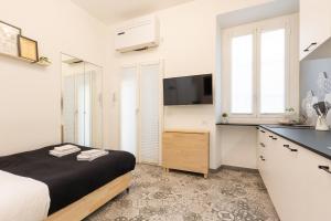 una camera con letto e una cucina con lavandino di Tiny & Tidy Studio in the key area of Milan a Milano