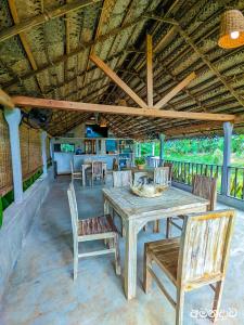 Un comedor con mesa y sillas de madera. en Amandawa Eco, en Gampaha