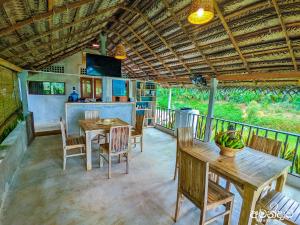 a porch with wooden tables and chairs and a kitchen at Amandawa Eco in Gampaha