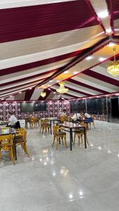 a restaurant with tables and chairs and purple ceilings at Wadi Rum party luxury camp in Disah