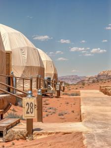 a couple of domes in the desert with a sign at Wadi Rum party luxury camp in Disah