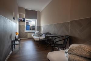 a room with chairs and a table and a bed at Hostel Kamienica Rynek 7 in Katowice