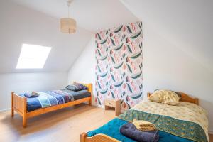 a bedroom with two beds and a wall at Gite le palefrenier - 6 pers - 10 min Etretat in Gonneville-la-Mallet