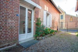 a door to a brick building with plants next to it at Gite le palefrenier - 6 pers - 10 min Etretat in Gonneville-la-Mallet