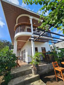 a house with a spiral staircase in front of it at Hostal Mamá Derlys in Moyogalpa