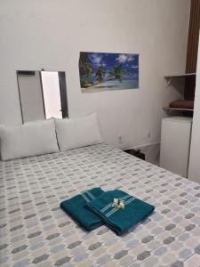 a room with a bed with a blue towel on it at Pousada Horizonte in Ilha de Boipeba