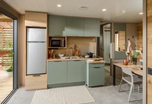 a kitchen with green cabinets and a white refrigerator at Coqslitscaux in Colleville +128 photos