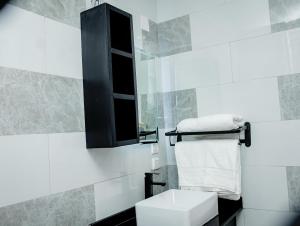 une salle de bain blanche avec toilettes et miroir dans l'établissement Rond Point Gorilla Boutique and Apartments, à Ruhengeri 119 autres photos