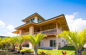 a house with palm trees in front of it at Nice Studio w/ AC near Kehena Beach and lava fields in Kehena
