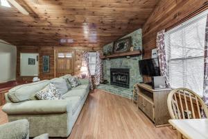 een woonkamer met een bank en een open haard bij Great Cabin with a View close to Dollywood! in Sevierville