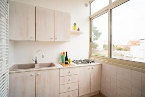 Una cocina con gabinetes blancos y un fregadero y una ventana. en Il gabbiano, en Otranto 35 fotos más