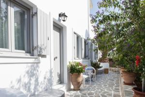 a corridor of a white building with potted plants at Apartments Klery - Studios 3 in Naousa