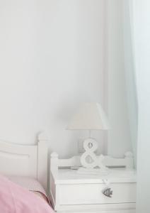 a lamp on a night stand next to a bed at Apartments Klery - Studios 3 in Naousa +3 photos