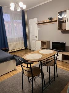 a living room with a table and chairs and a bed at Gaby apartman in Tiszaújváros