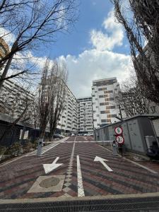 an empty street with white arrows in a city at Minimalist Green & Grey Flat in Bucharest