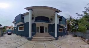 een blauw-wit gebouw met een veranda bij Centurion Aparthotel in Abuja