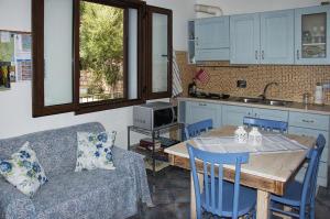 a living room with a table and a kitchen with a couch at FioreRosa in Santa Maria Navarrese +54 photos