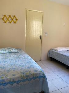 a bedroom with two beds and a door to a room at Amplo apto com garagem, próximo shopping Jardins in Aracaju