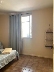 a bedroom with a bed and a window at Amplo apto com garagem, próximo shopping Jardins in Aracaju