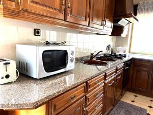 a kitchen counter with a microwave and a sink at Casa do Tojal in Fiscal +13 photos