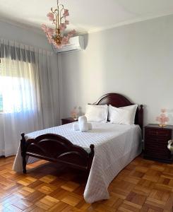 a bedroom with a bed and a chandelier at Casa do Tojal in Fiscal