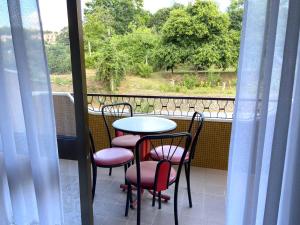 a balcony with a table and chairs and a window at Casa do Tojal in Fiscal
