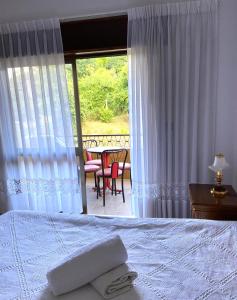 a bedroom with a bed and a view of a patio at Casa do Tojal in Fiscal