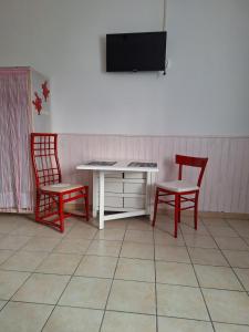 a room with two chairs and a desk and a tv at Tiny Torbiera in Val di Chy