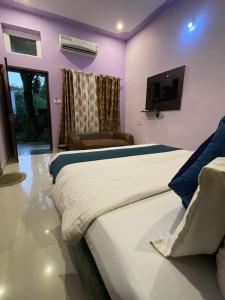 a bedroom with two beds and a tv on the wall at Green Hub-Pool Villa with Nature in Pushkar