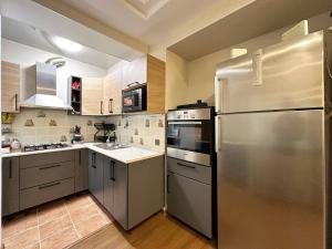 a large kitchen with a stainless steel refrigerator at Cozy Retreat in Green Dúbravka in Bratislava