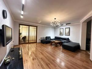 a living room with a black couch and a tv at Cozy Retreat in Green Dúbravka in Bratislava
