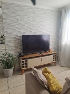 a living room with a flat screen tv on a cabinet at Property located in Guaratiba in Monteiro