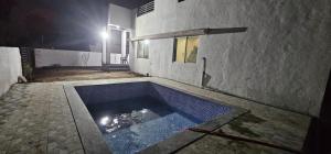 una piscina di fronte a un edificio di notte di Advikam Nest a Murbād