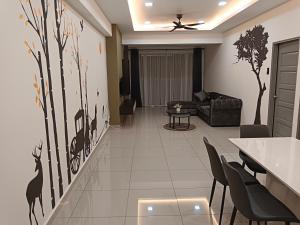 a living room with a couch and trees on the wall at Happy Homestay TheVenus Sitiawan in Sitiawan