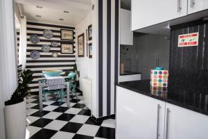 a kitchen with a black and white checkered floor at Cocas House II - Almada in Almada