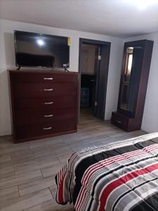 a bedroom with a dresser and a flat screen tv at GR20ACD Regina in Cuauhtémoc