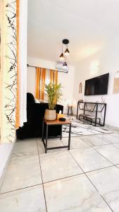 a living room with a couch and a table at Maison La Luciole LOUIS in Libreville