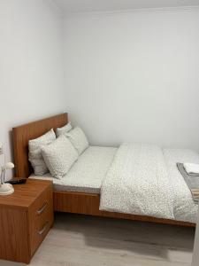 a bedroom with a bed with a wooden headboard at Apartament Ultracentral in Rădăuţi